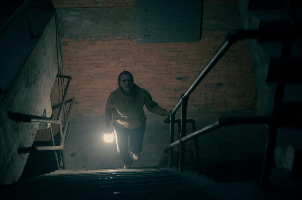 June (Elisabeth Moss) monte un escalier dans le noir